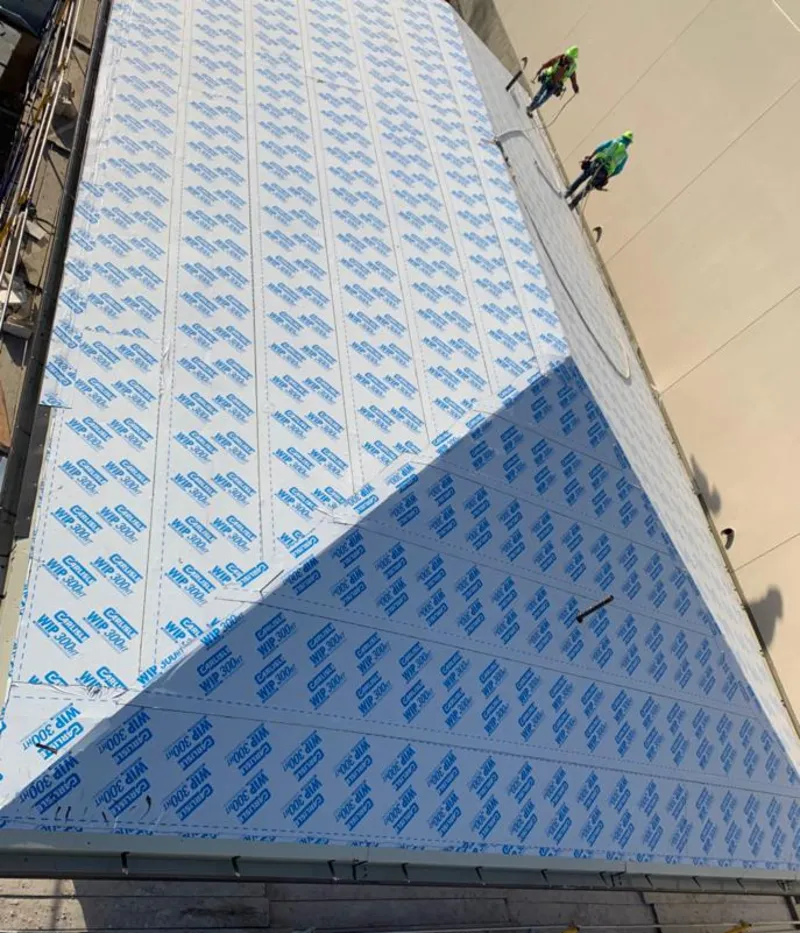 Professional roofers installing underlayment on a metal roof in Bangor Base